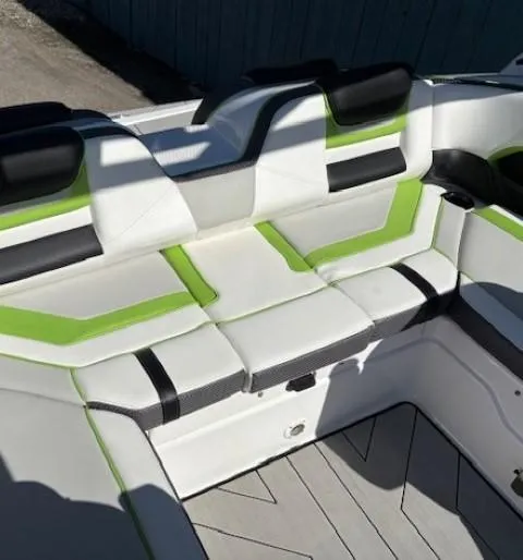 Slide: The Image of 2021 Yamaha Boats 212XE interior with green and black accents, modern seating design. - 20