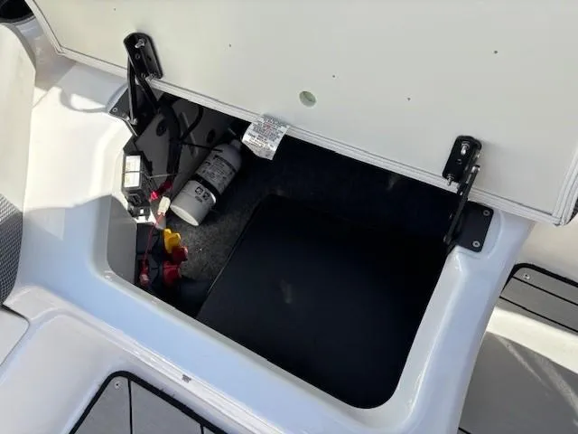 Slide: The Image of Open storage compartment in 2021 Yamaha Boats 212XE, showing interior components. - 22