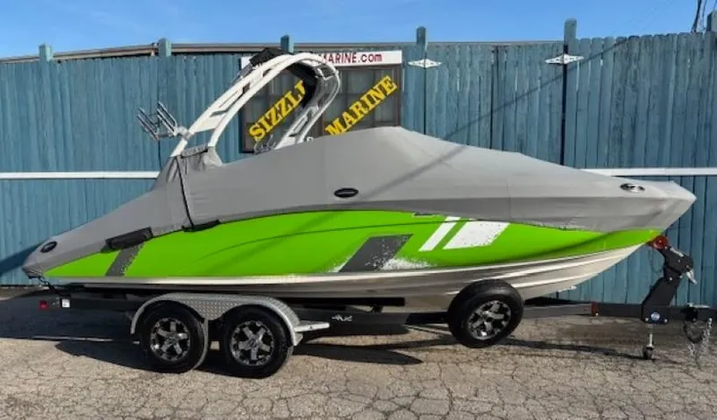 Slide: The Image of 2021 Yamaha Boats 212XE, green and gray, covered on a trailer. - 28