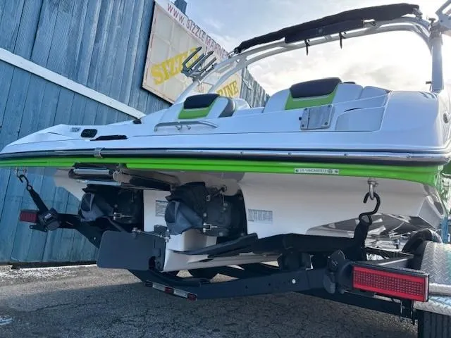 Slide: The Image of 2021 Yamaha Boats 212XE with green accents on a trailer, rear view. - 5