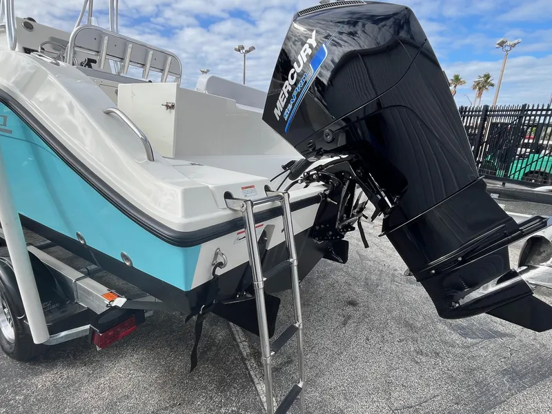 Slide: The Image of 2021 Cobia 237 Center Console boat with Mercury outboard motor and swim ladder. - 7