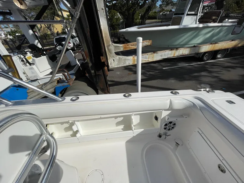 Slide: The Image of 1997 Wellcraft 302 boat interior with seating and storage, parked near another boat on a trailer. - 17
