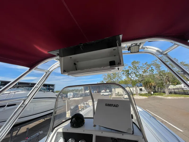 Slide: The Image of 1997 Wellcraft 302 boat helm with Simrad navigation, under maroon canopy. - 19