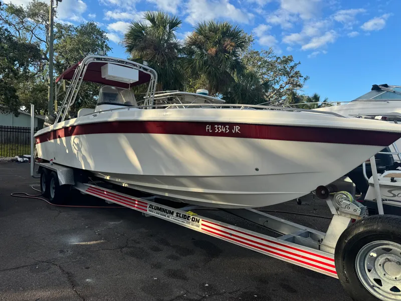 Slide: The Image of 1997 Wellcraft 302 boat on trailer, parked outdoors under a blue sky. - 2