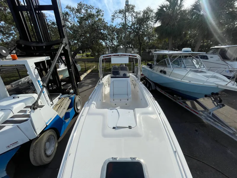 Slide: The Image of 1997 Wellcraft 302 boat on trailer, surrounded by trees and equipment. - 31