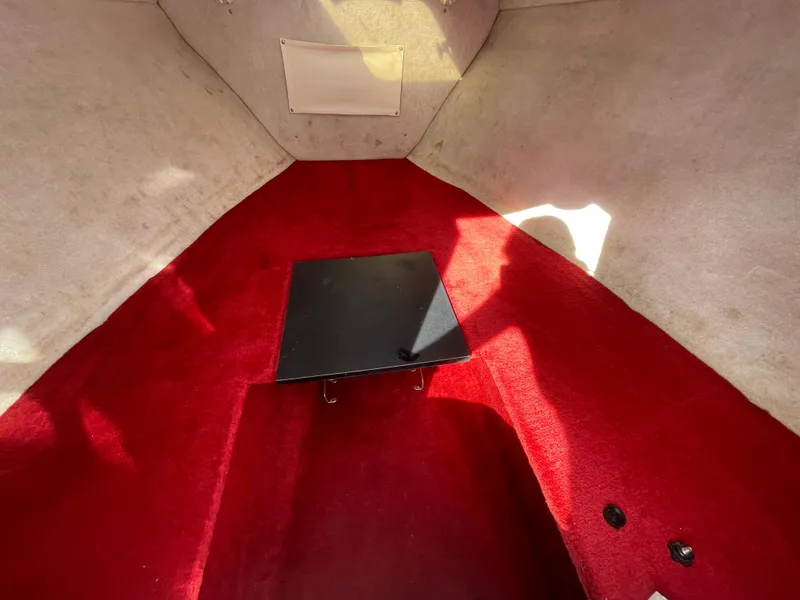 Slide: The Image of Interior of 1997 Wellcraft 302 boat with red carpet and black table. - 40