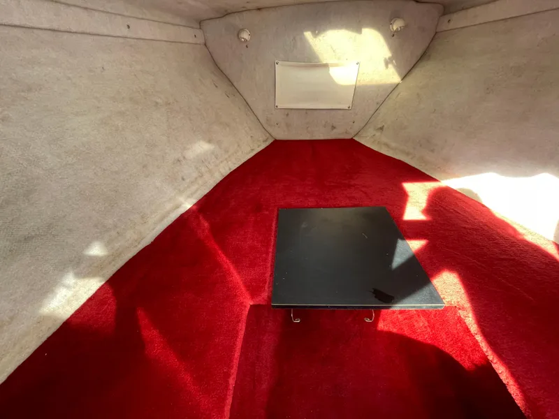 Slide: The Image of Interior of 1997 Wellcraft 302 boat with red carpet and small table. - 41