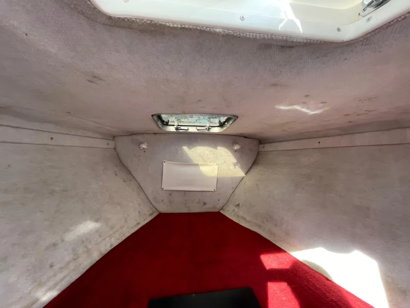 Slide: The Image of Interior cabin of a 1997 Wellcraft 302 boat with red carpet and overhead hatch. - 45