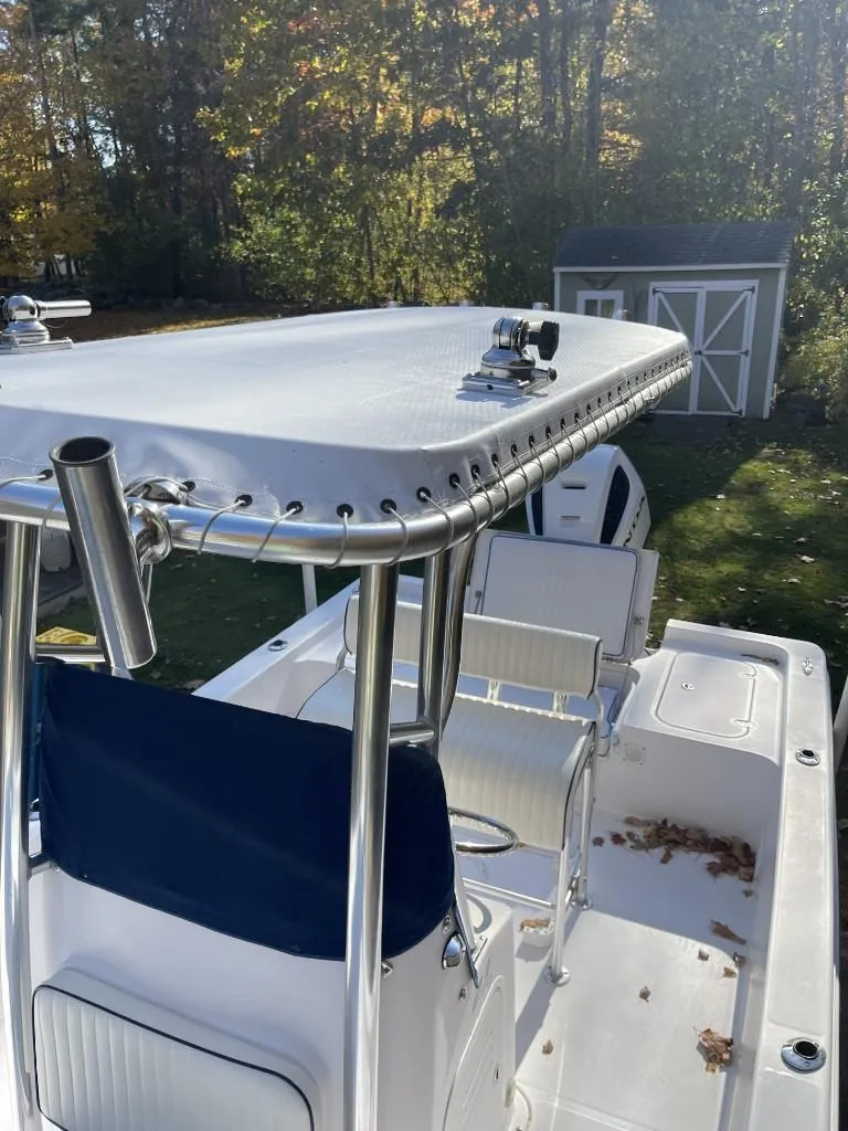 Slide: The Image of 2009 Pro-Line 23 Bay boat with T-top and seating, outdoors near a shed. - 10