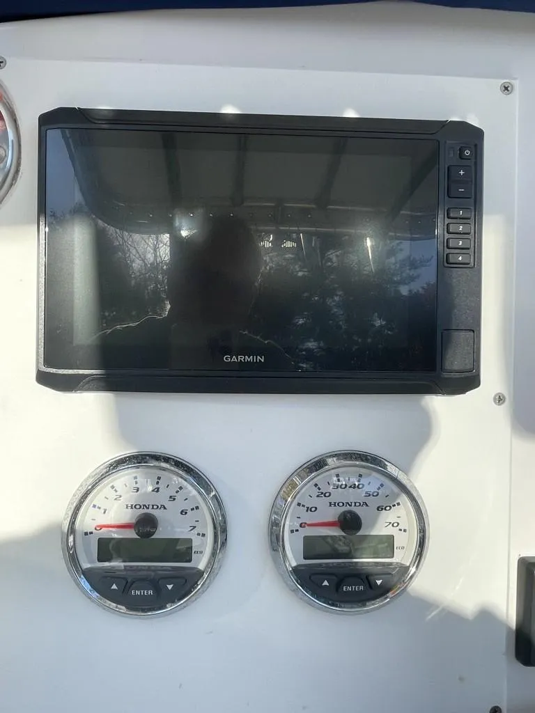 Slide: The Image of Garmin display and Honda gauges on 2009 Pro-Line 23 Bay boat dashboard. - 13