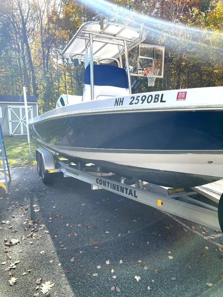 Slide: The Image of 2009 Pro-Line 23 Bay boat on trailer in driveway, surrounded by autumn trees. - 2