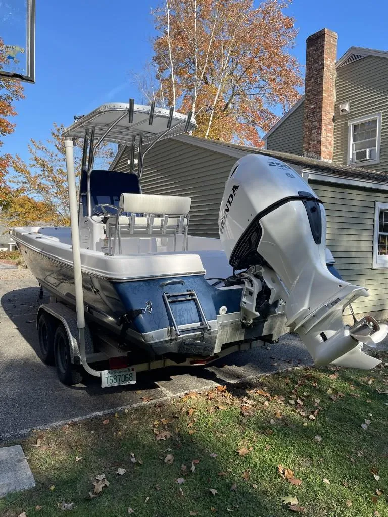Slide: The Image of 2009 Pro-Line 23 Bay boat with Honda outboard motor on trailer, parked in driveway. - 3