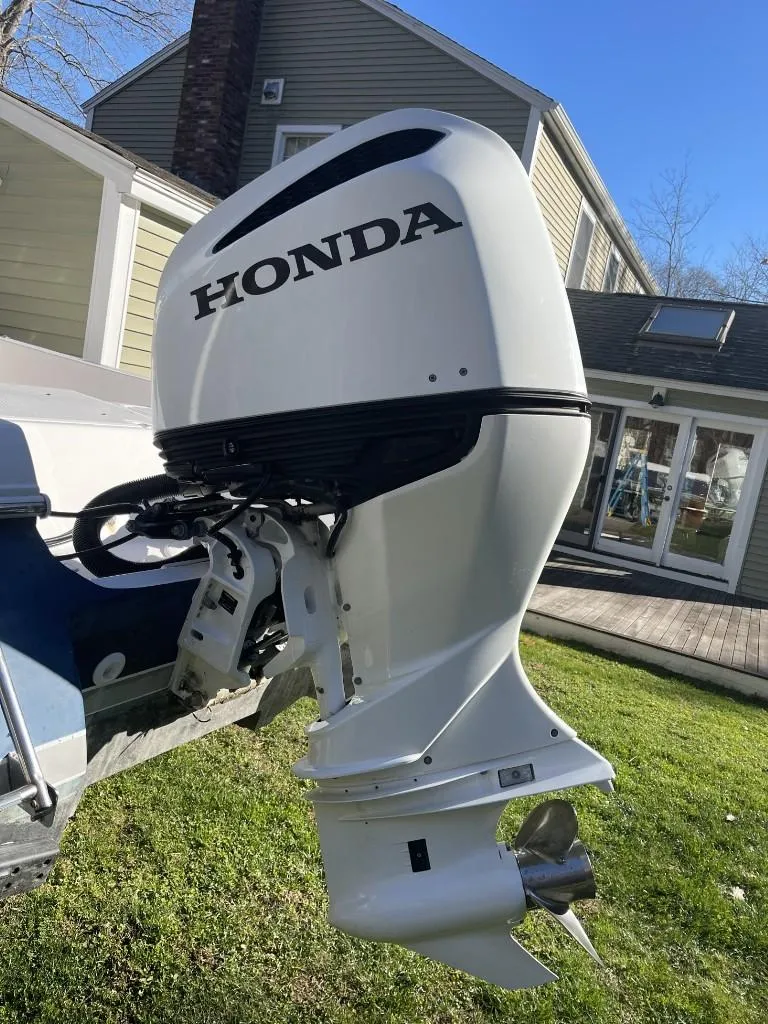Slide: The Image of 2009 Pro-Line 23 Bay boat with Honda outboard motor in residential setting. - 6