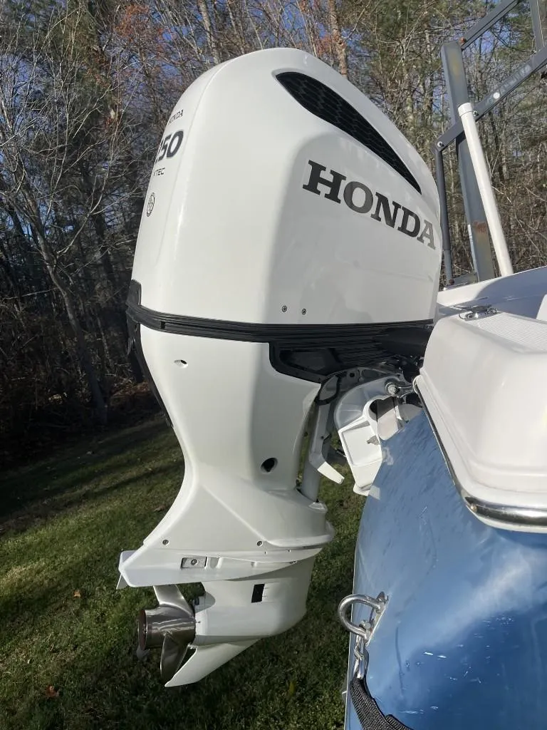 Slide: The Image of 2009 Pro-Line 23 Bay boat with Honda outboard motor in a wooded area. - 7