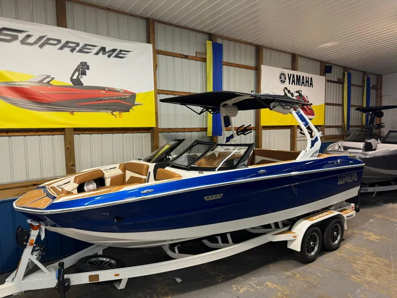 Slide: The Image of 2024 Supreme S220 boat in showroom, blue exterior, on trailer. - 30