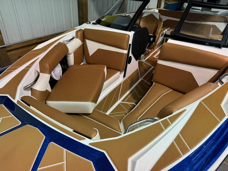 Slide: The Image of 2024 Supreme S220 boat interior with tan and white seating, blue accents. - 31
