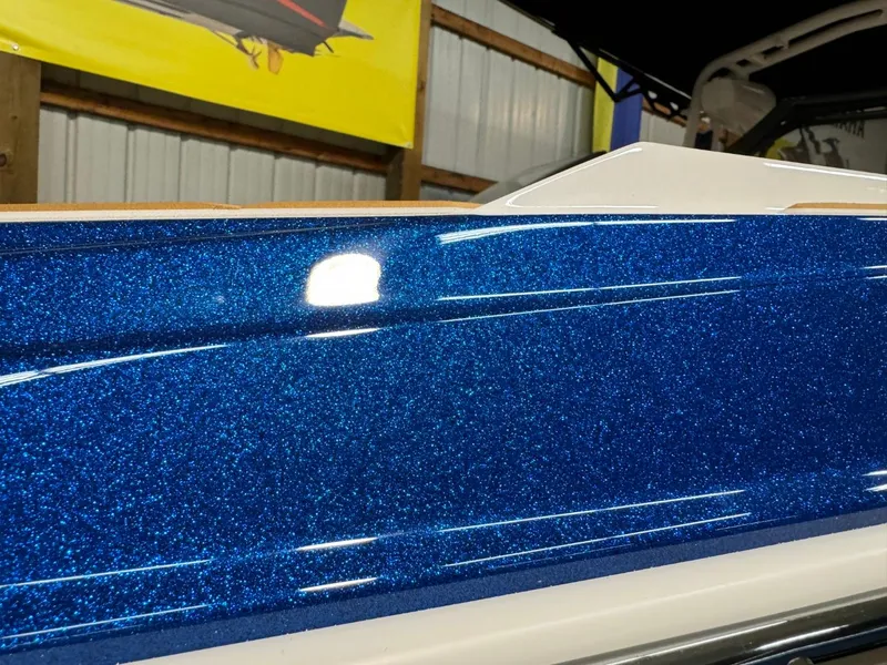 Slide: The Image of 2024 Supreme S220 boat with sparkling blue finish in a showroom. - 34
