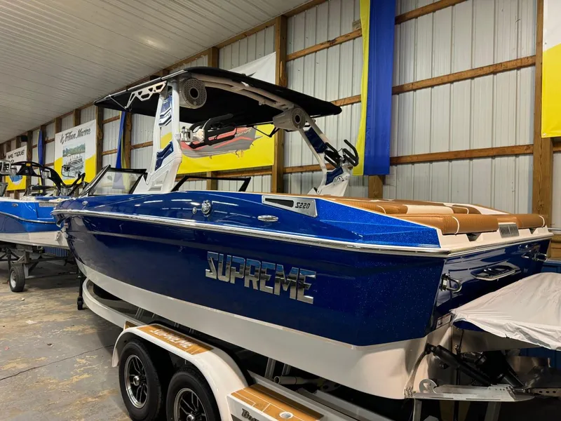 Slide: The Image of 2024 Supreme S220 boat in showroom, blue exterior, on trailer. - 35
