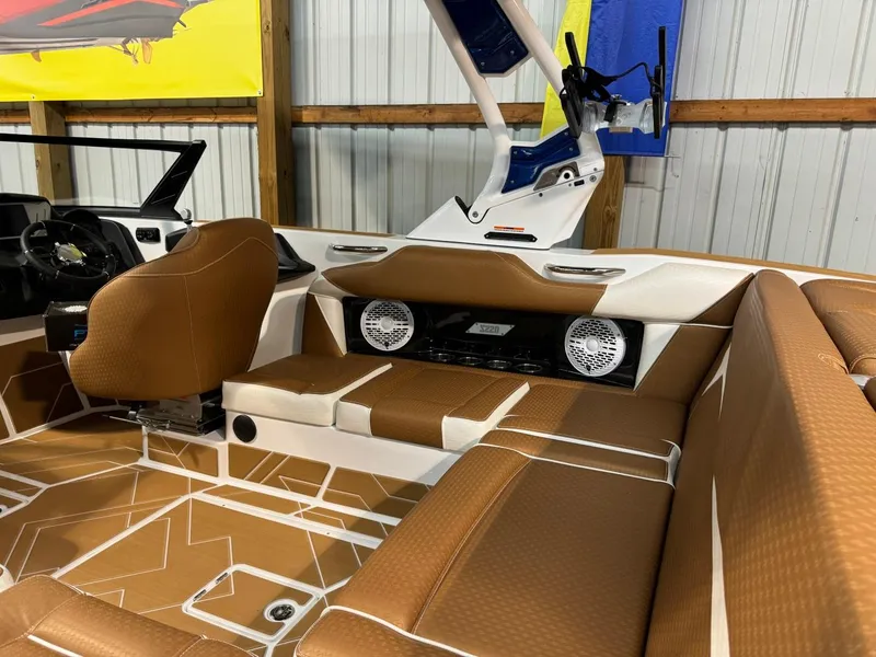 Slide: The Image of 2024 Supreme S220 boat interior with brown seating and modern audio system. - 39