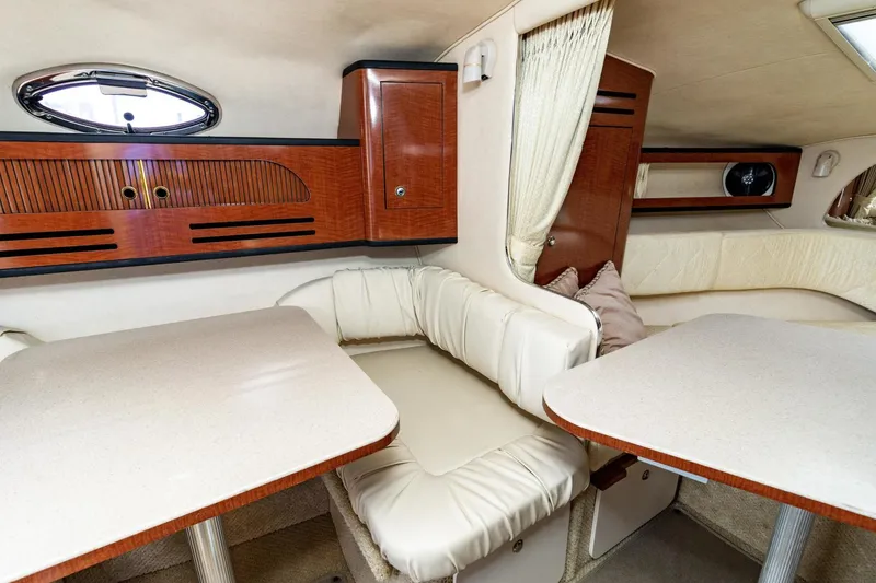 Slide: The Image of Interior of 2004 Sea Ray 280 Sundancer with cozy seating and wooden cabinetry. - 13