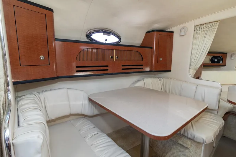 Slide: The Image of Luxurious 2004 Sea Ray 280 Sundancer cabin interior with dining area and wood cabinetry. - 14