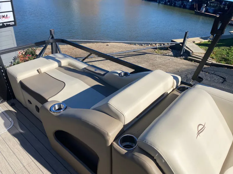 Slide: The Image of 2025 SunCatcher Select 324SS pontoon boat with beige seating by the water. - 14