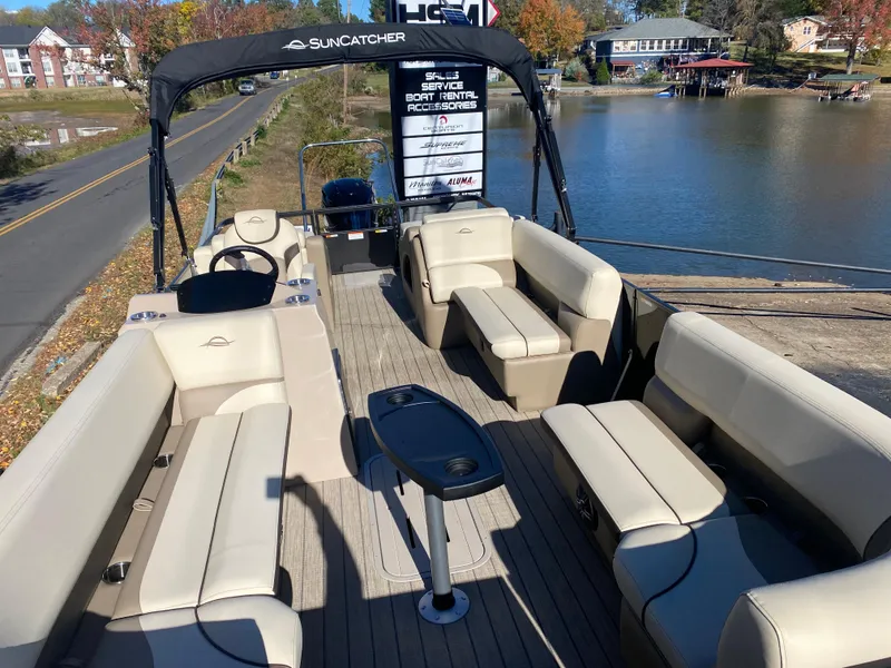 Slide: The Image of 2025 SunCatcher Select 324SS pontoon boat with spacious seating, docked by a scenic lake. - 16