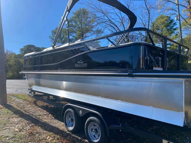 Slide: The Image of 2025 SunCatcher Select 324SS pontoon boat on trailer, parked outdoors. - 2