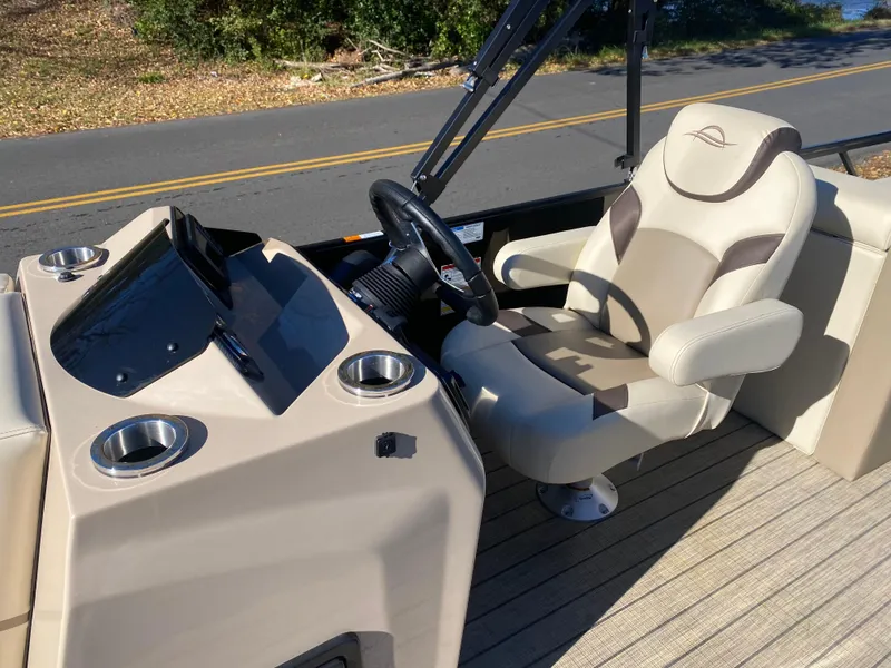 Slide: The Image of 2025 SunCatcher Select 324SS boat interior with steering wheel and captain's chair. - 6