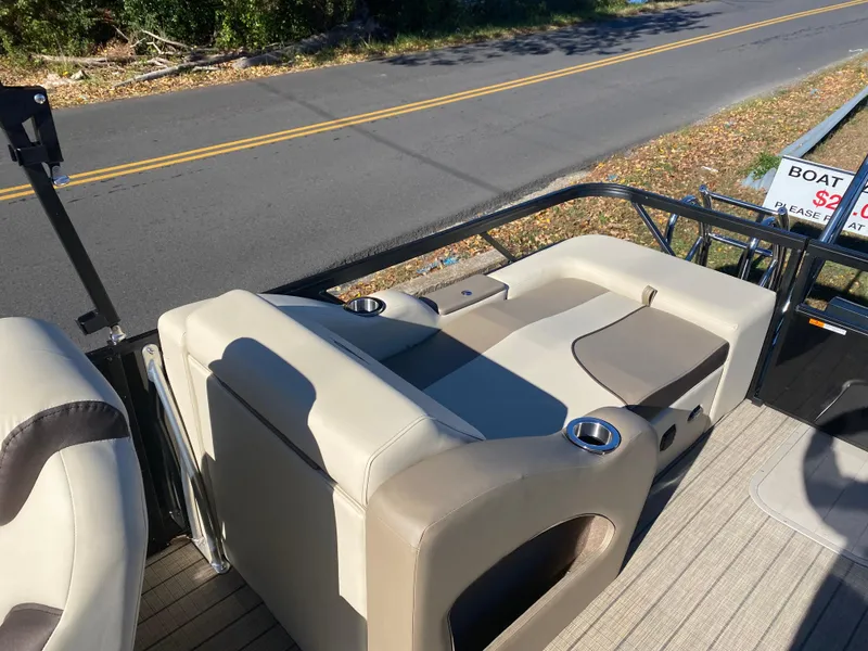 Slide: The Image of 2025 SunCatcher Select 324SS boat interior with beige seating and cup holders. - 9