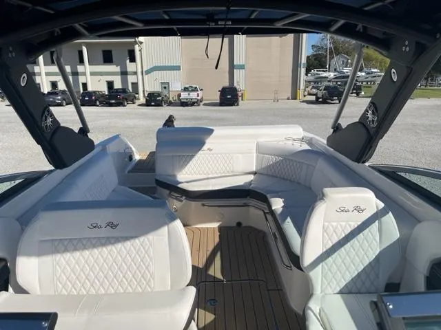 Slide: The Image of 2022 Sea Ray SLX 280 boat interior with white seating and wood flooring. - 14