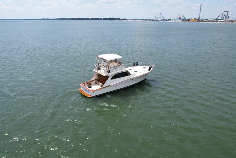 Slide: The Image of 1981 Post 46 Sportfish boat on open water, distant amusement park in background. - 12