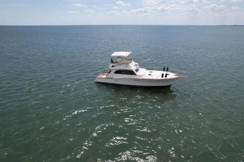 Slide: The Image of 1981 Post 46 Sportfish boat on open water under a clear sky. - 13