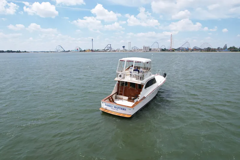 Slide: The Image of 1981 Post 46 Sportfish boat on open water with amusement park in background. - 14