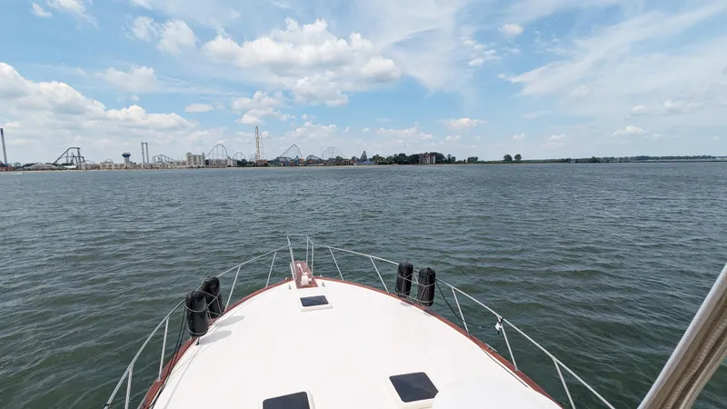 Slide: The Image of 1981 Post 46 Sportfish boat on open water with amusement park in background. - 17