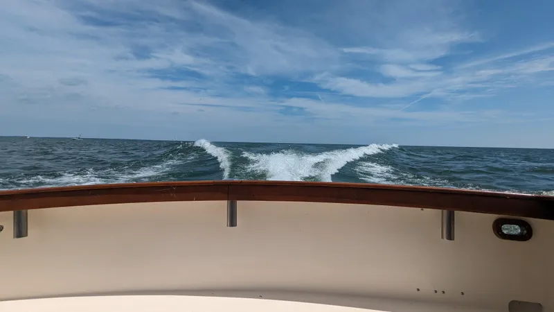 Slide: The Image of 1981 Post 46 Sportfish boat cruising on open sea under blue sky. - 19