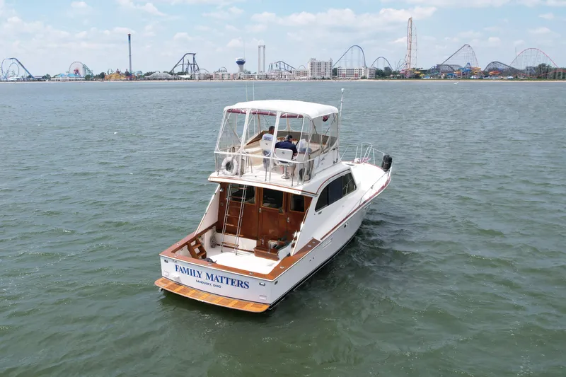 Slide: The Image of 1981 Post 46 Sportfish boat on water with amusement park in background. - 2