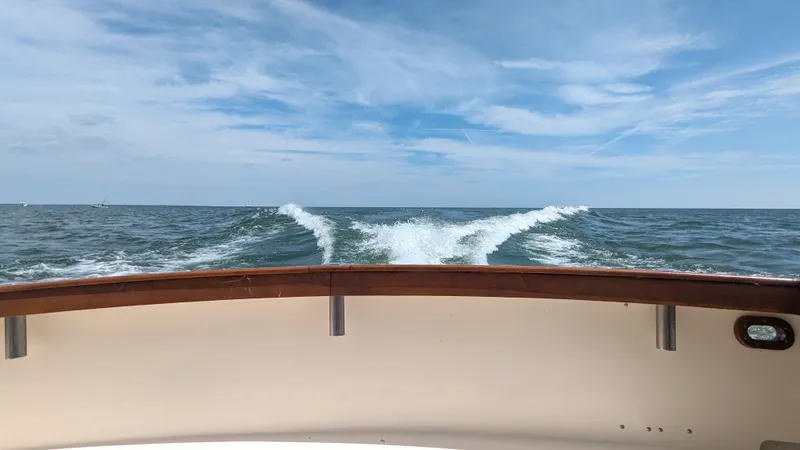 Slide: The Image of 1981 Post 46 Sportfish boat cruising on open sea under blue sky. - 20