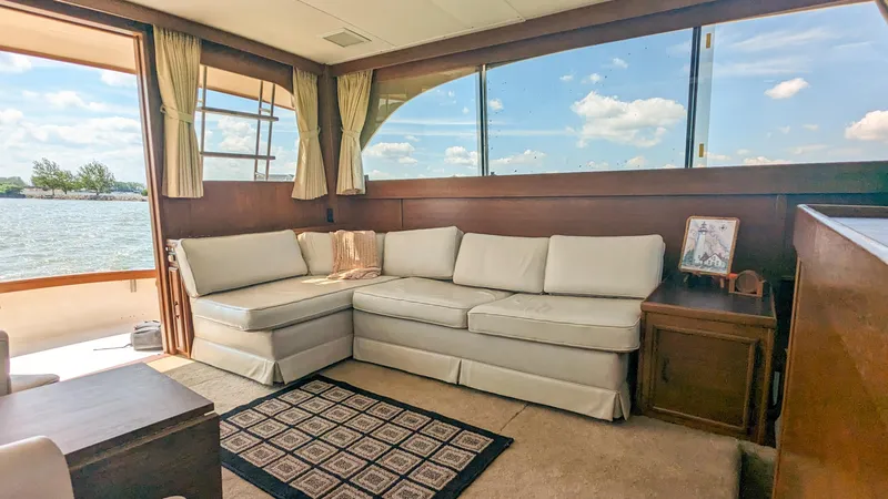 Slide: The Image of 1981 Post 46 Sportfish yacht interior with beige sofa, large windows, and scenic water view. - 31