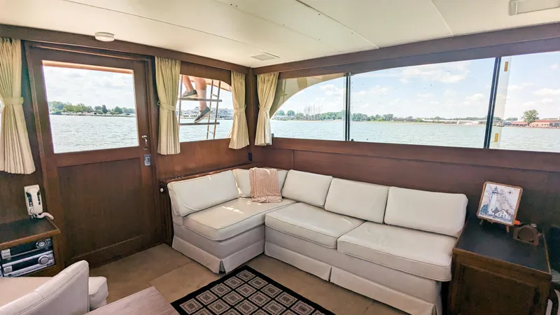 Slide: The Image of 1981 Post 46 Sportfish yacht interior with white sofa and large windows overlooking water. - 35