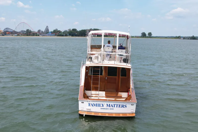 Slide: The Image of 1981 Post 46 Sportfish boat "Family Matters" on water, amusement park in background. - 4