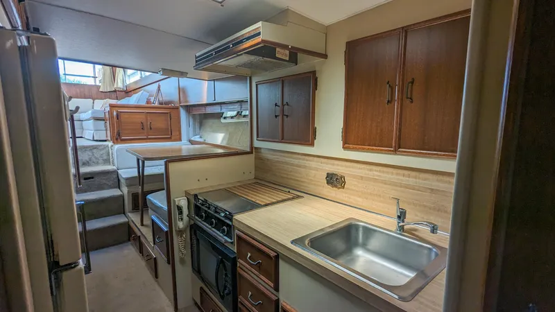 Slide: The Image of 1981 Post 46 Sportfish boat kitchen with wooden cabinets and stainless steel sink. - 41
