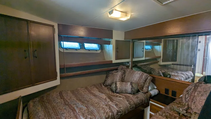 Slide: The Image of 1981 Post 46 Sportfish cabin interior with twin beds and wood paneling. - 44