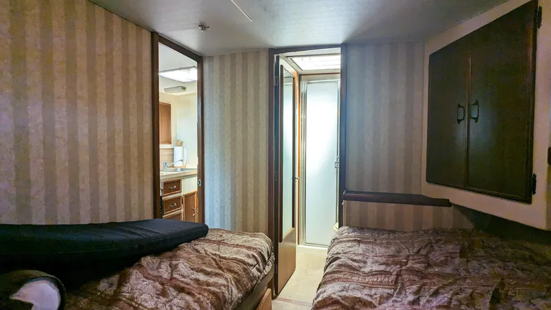 Slide: The Image of 1981 Post 46 Sportfish cabin interior with twin beds and striped wallpaper. - 46
