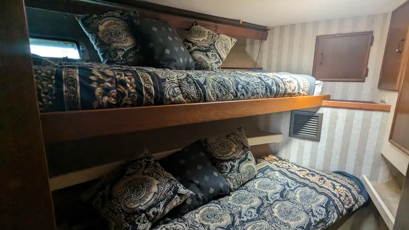 Slide: The Image of 1981 Post 46 Sportfish cabin with bunk beds and patterned bedding. - 49