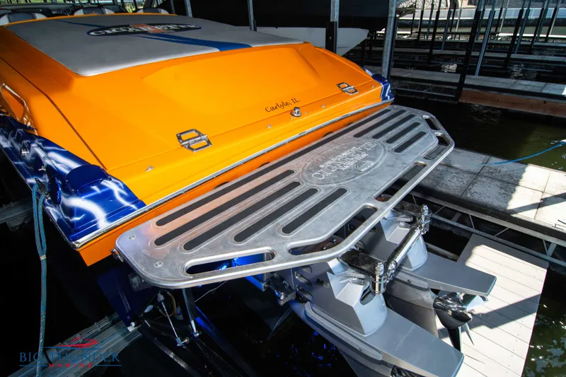 Slide: The Image of 2007 Cigarette 42X boat with vibrant orange and blue design, docked in a marina. - 11