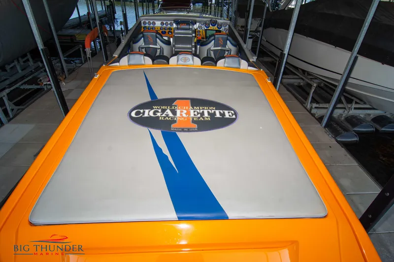 Slide: The Image of 2007 Cigarette 42X powerboat with vibrant orange and blue design, docked indoors. - 12