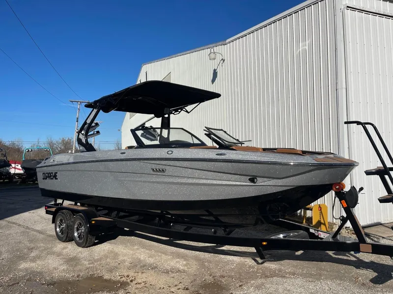 Slide: The Image of 2024 Supreme S240 boat on trailer, parked outdoors near a building. - 11