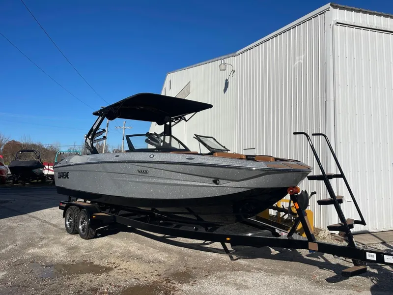 Slide: The Image of 2024 Supreme S240 boat on trailer, parked outdoors near a building. - 12