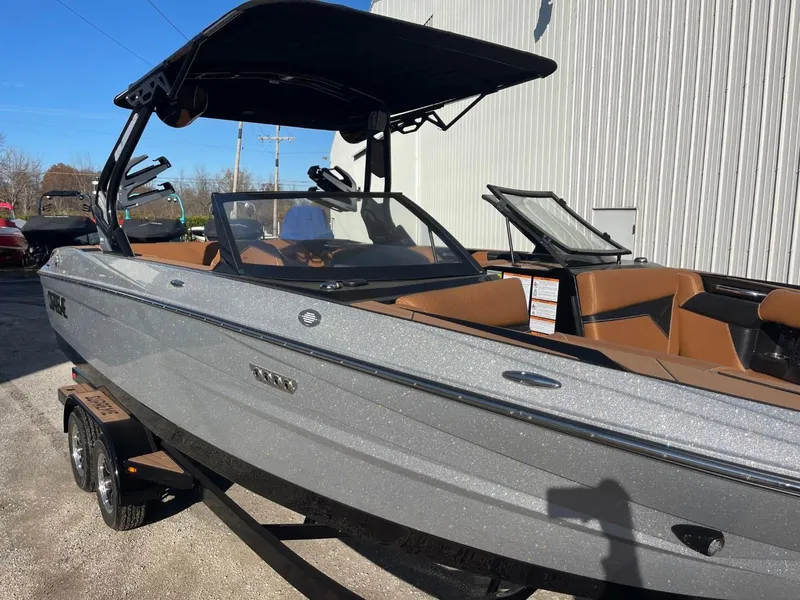 Slide: The Image of 2024 Supreme S240 boat with sleek design and modern features, parked outdoors. - 16